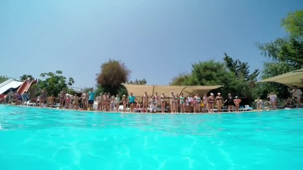 Люди прыгают в бассейн — стоковое видео