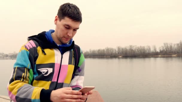 Homme avec un smartphone sur le front de mer — Video