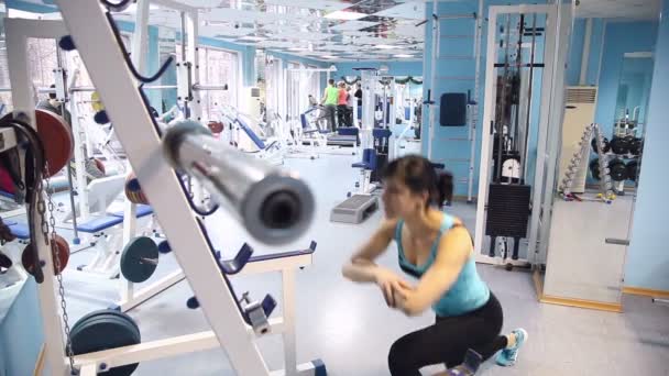 Fille squats dans la salle de gym — Video