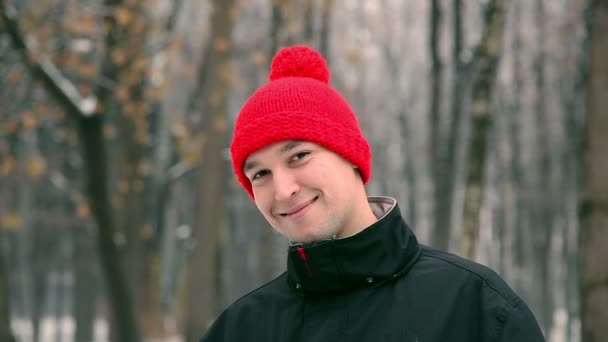 Man in een rode GLB glimlacht — Stockvideo