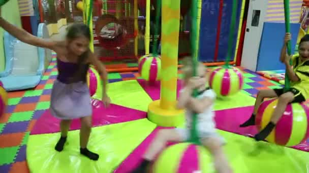 Дети на карусели в игровом центре — стоковое видео