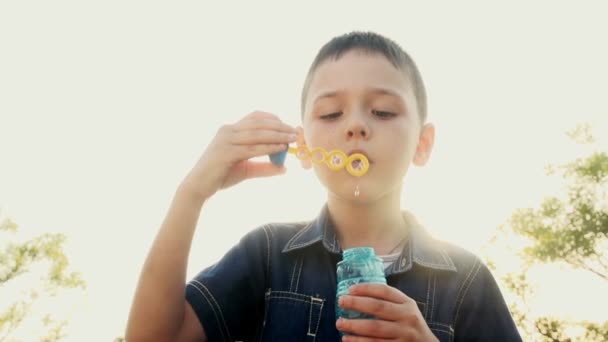Boy blowing soap bubbles — Stock Video