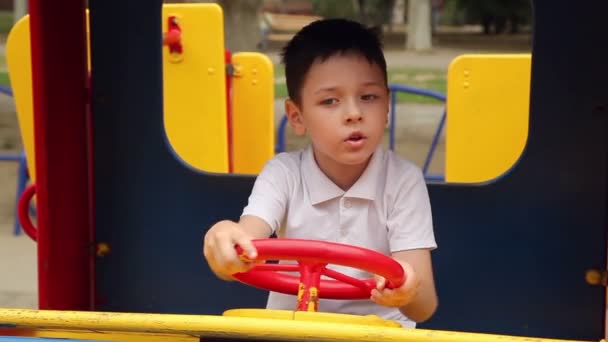 Мальчик за рулем игрушечной машины — стоковое видео