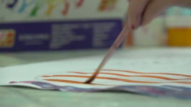 Çocuk bir fırça tuval üzerine çizer.