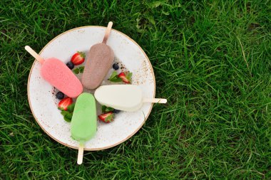 dondurma çimenlerin üzerinde saçtan. Sırlı renkli buzlu şeker. Summe