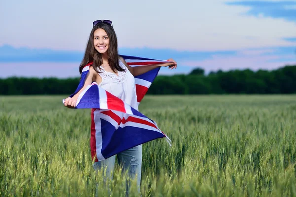 Young smiling girl in a field of wheat. Flag of the England Royalty Free Stock Images
