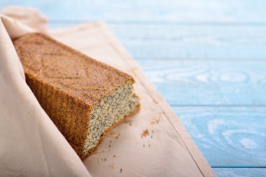 haşhaş tohumu ile pasta mavi ahşap backg bir peçeteye sarılmış