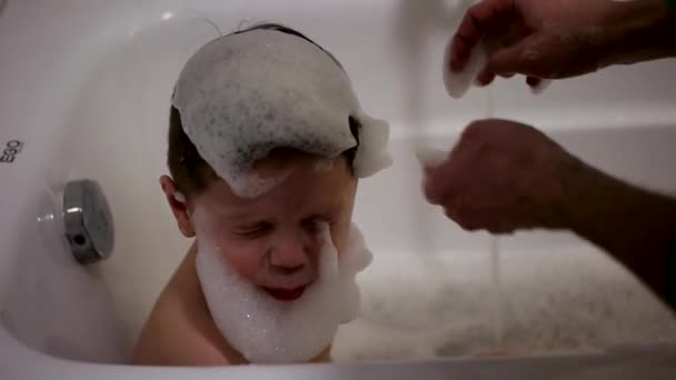 Un bébé joue avec des bulles tout en prenant un bain — Video