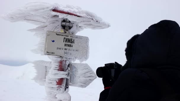 Fotógrafo que faz a foto do sinal congelado da direção — Vídeo de Stock