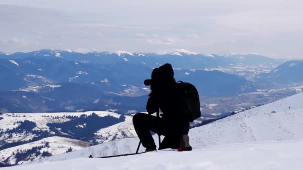 Fotograf przy strzale w górach zimą. — Wideo stockowe