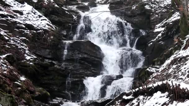 Быстрый поток воды в водопаде зимой — стоковое видео