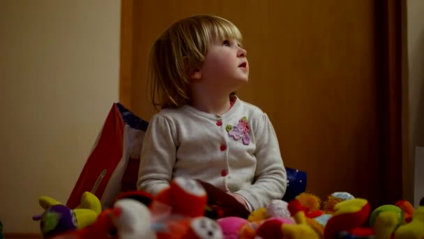 Mała dziewczynka siedzi na podłodze i gry zabawki — Wideo stockowe