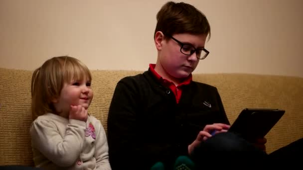 Сестра и брат играют в игры на планшете — стоковое видео