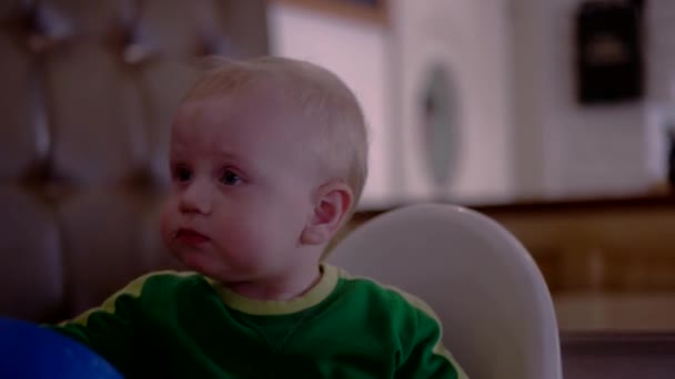 Baby Boy sitter i barnstol roar sig i cafeterian — Stockvideo