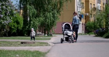 Anne ile bebek arabası açık havada yürüyüş ile küçük çocuk