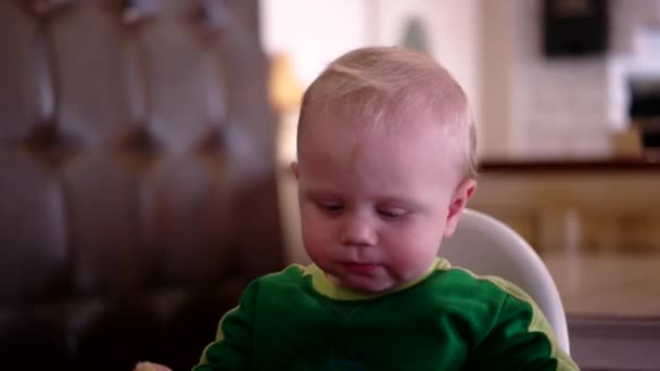 Baby fiú ülő-ban szórakozás a Cafeteria etetőszék — Stock videók