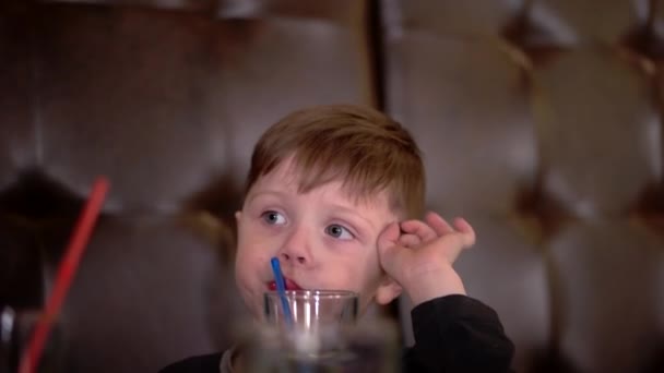 Niño bebiendo jugo y comiendo pizza en la cafetería — Vídeo de stock