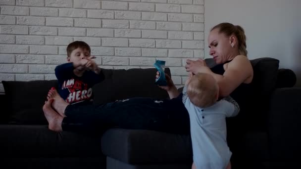 Mother Rest on a Couch While Her Sons Playing Around — Stock Video