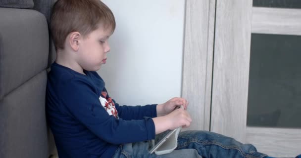 Niño viendo dibujos animados en una tableta, Vista lateral — Vídeos de Stock