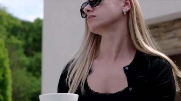 Jonge zakenvrouw in in zonnebril op een Cafe in de buitenlucht. — Stockvideo