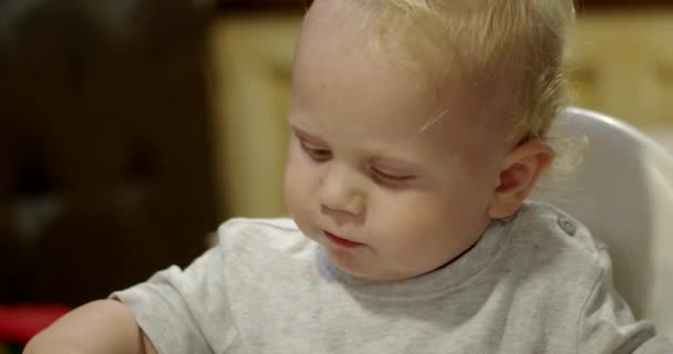 Aranyos kisfiú először pizzát eszik. Közelről — Stock videók