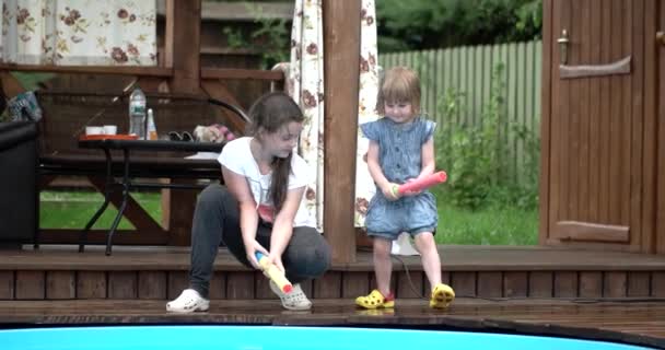 Duas meninas bonitos disparando água com Squirt Gun e se divertindo — Vídeo de Stock
