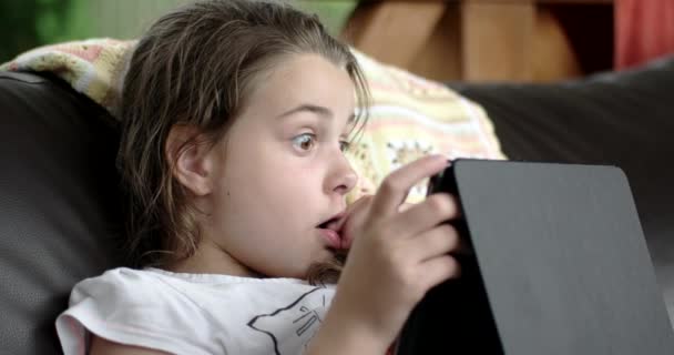 Niña usando Tablet Computer en el sofá en la terraza — Vídeos de Stock