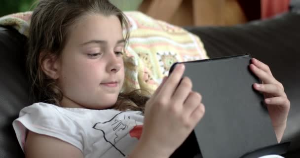 Niña usando Tablet Computer en el sofá en la terraza — Vídeos de Stock