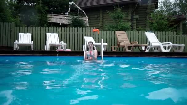 Дівчина стріляє воду зі шприц пістолета в камеру — стокове відео