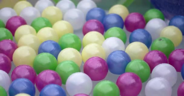 Bolas de colores flotando en la superficie del agua de una piscina — Vídeos de Stock