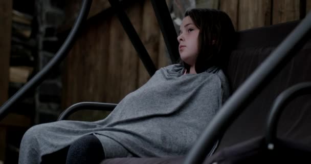 Маленька дівчинка сидить на гойдалці на задньому дворі — стокове відео