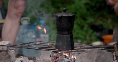Kahve makinesi üzerinde bir kamp ateşi sisli ormanın içinde kaynar. Kahve kahve Maker'da şenlik ateşi kaynama olduğunu