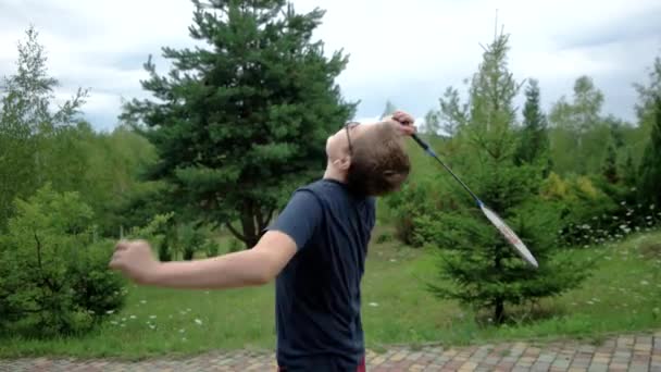 Niño pequeño con raqueta y lanzadera jugando al bádminton y divirtiéndose al aire libre — Vídeos de Stock