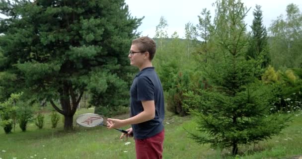 Liten pojke med Racket och badmintonbollen Spela Badminton och ha kul utomhus — Stockvideo