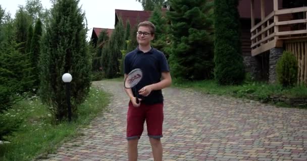 Petit garçon avec raquette et navette jouant au badminton et s'amusant à l'extérieur — Video