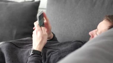 Tv izlerken, uzak tutarak kanepenin üzerinde çekici bir adam yalan