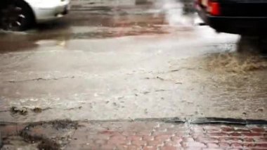 Arabalar su sıçramalarına su birikintisi üzerinde su dolu sokak ağır çekim