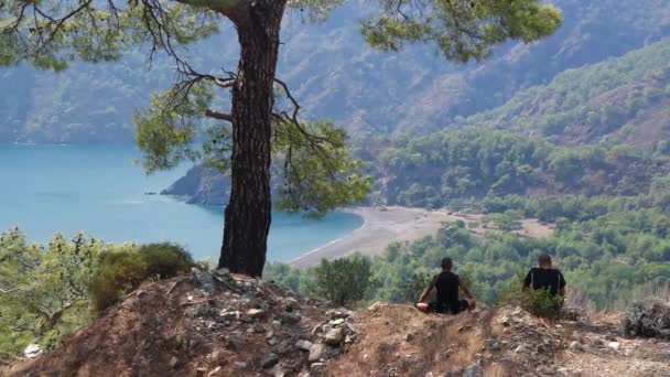 Jóvenes excursionistas disfrutando de la vista desde el pico de la montaña — Vídeo de stock