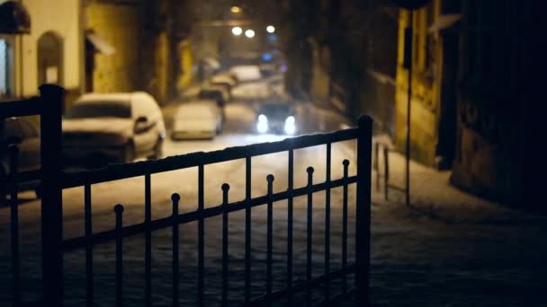 Ur fokus bil lampor på snöar street i natt. Slow motion — Stockvideo