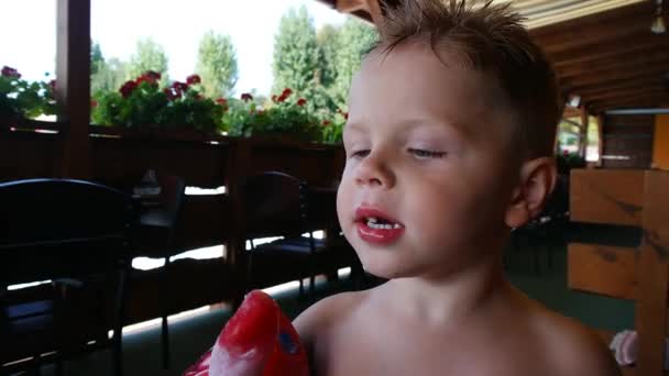 Kleine schattige jongen likken ijs gedurende de zomermaanden — Stockvideo