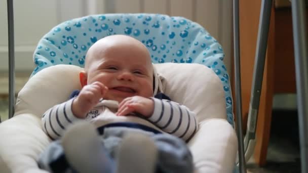 Gelukkig meisje schattige baby swing in elektrische schommel op woonkamer. — Stockvideo