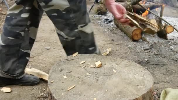 Onbeholpen man hakt hout in de openlucht met een bijl. — Stockvideo