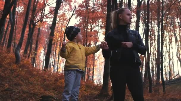 Mooie moeder en kindje in de herfst bos. Jongen shout — Stockvideo