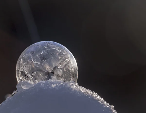 Zmrazená bubble na sněhu v západu slunce — Stock fotografie