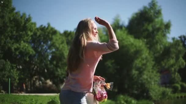 Μια γυναίκα που τροφοδοτεί ένα πουλιά στο πάρκο — Αρχείο Βίντεο