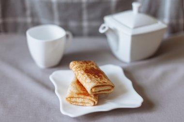 çay ve gri kumaş üzerinde kahvaltı ile doldurulmuş krep 