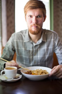 bir adam bir kafede yemek noodles Asya