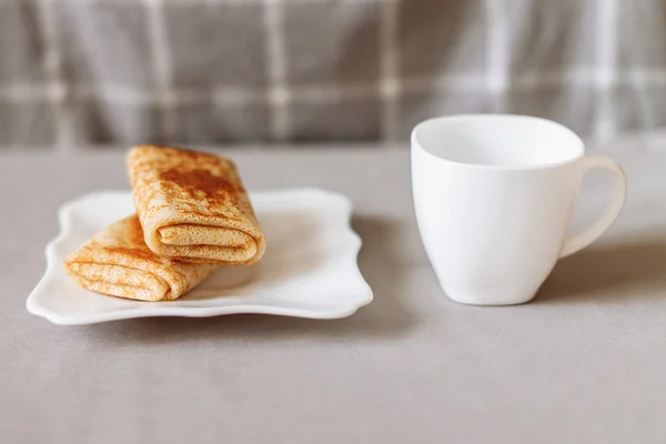 Pfannkuchen gefüllt mit Tee und Frühstück auf grauem Stoff — Stockfoto