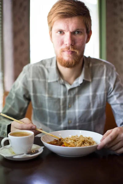 bir adam bir kafede yemek noodles Asya