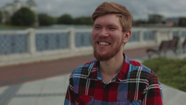 Close-up van portret tevreden jonge man die lacht op camera — Stockvideo